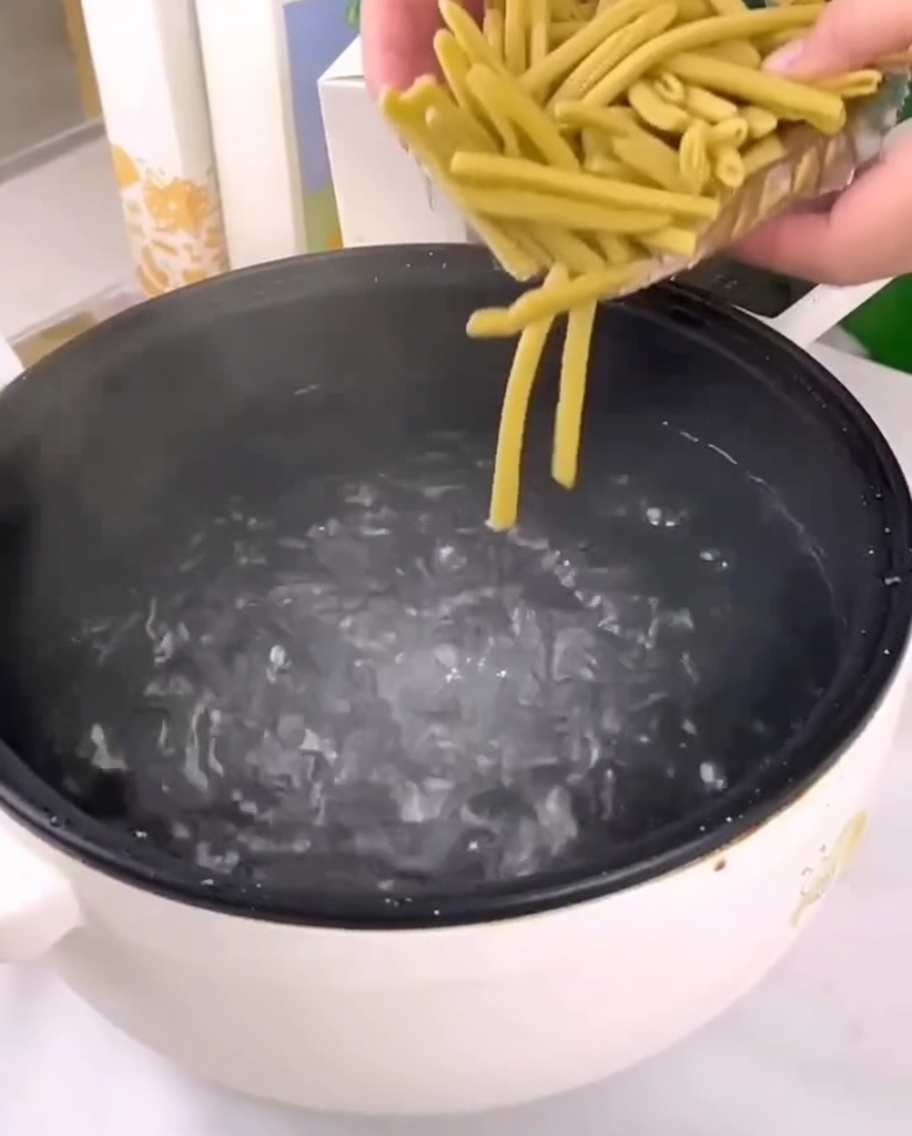 Penne de millet crues versées dans une casserole deau bouillante.