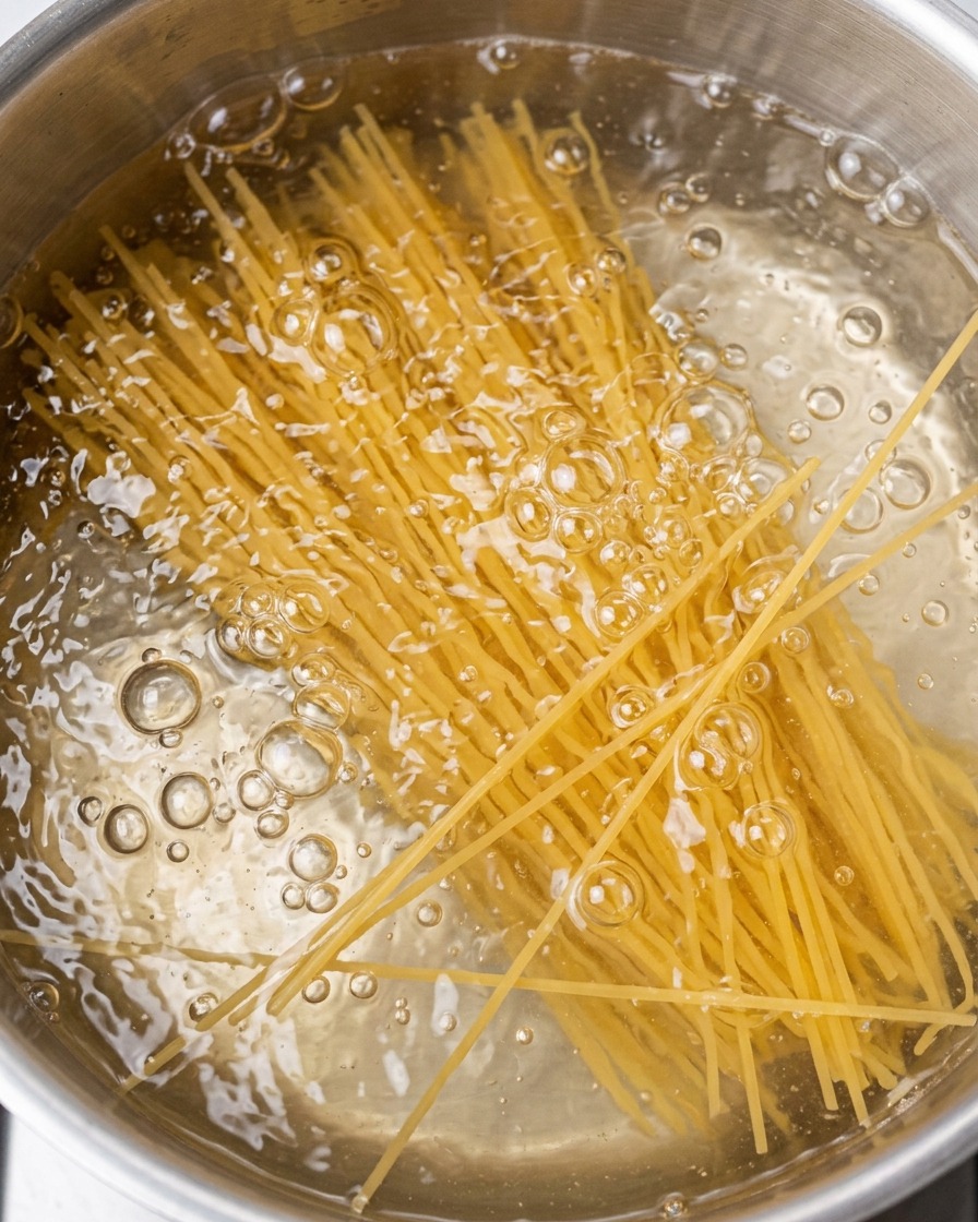 Spaghettis en train de cuire dans une casserole deau bouillante.