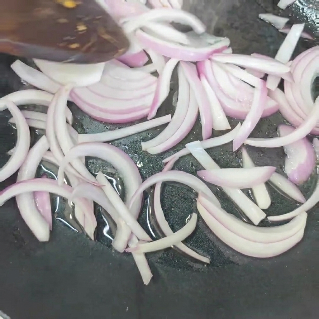 Oignons en train de frire à la poêle jusquà ce quils soient tendres.