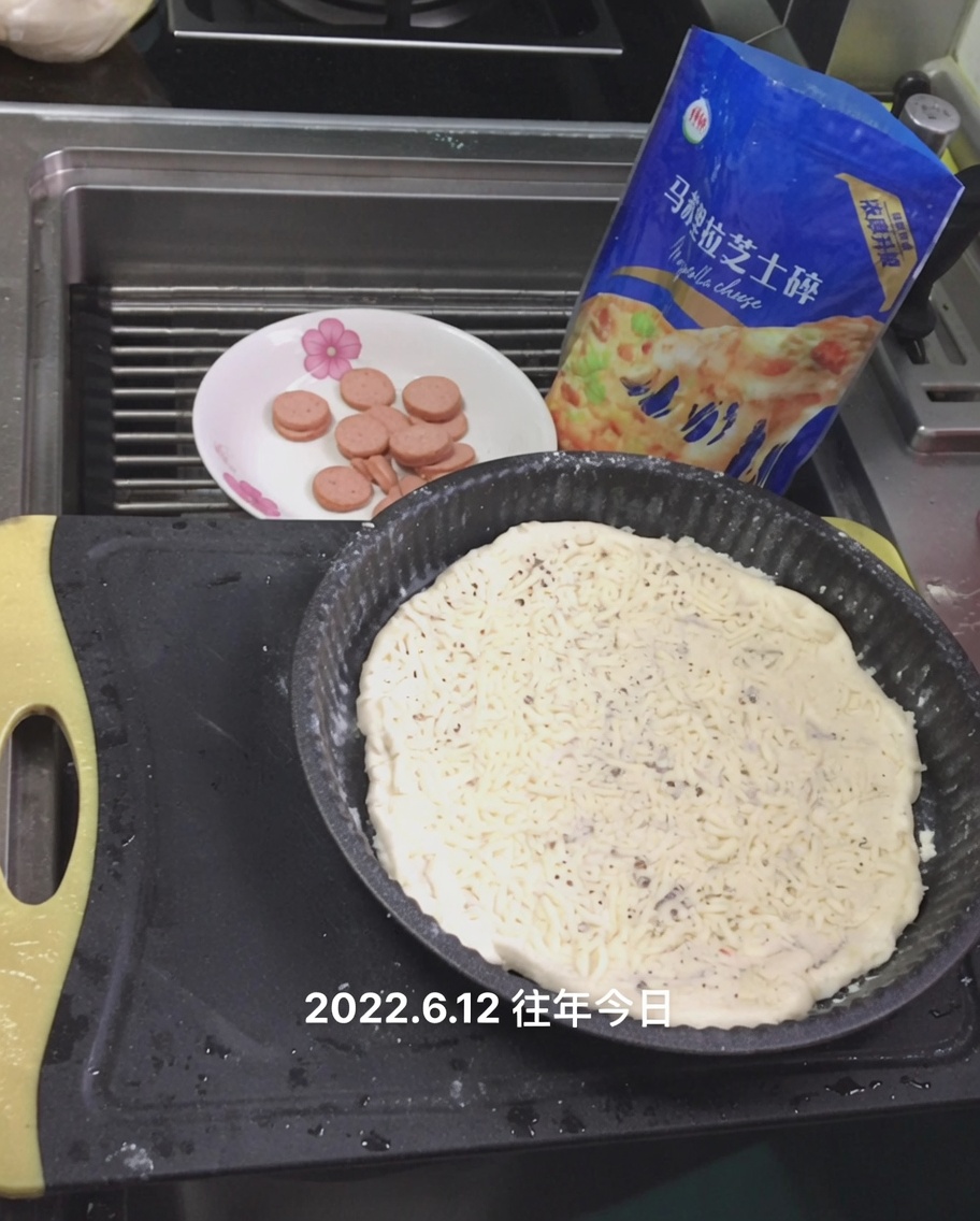 Mozzarella râpée saupoudrée sur la sauce blanche sur la pâte à pizza.