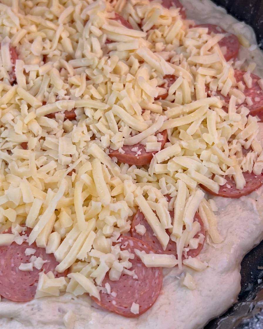 La pizza glissée dans le four chaud pour commencer les 10 minutes de cuisson.