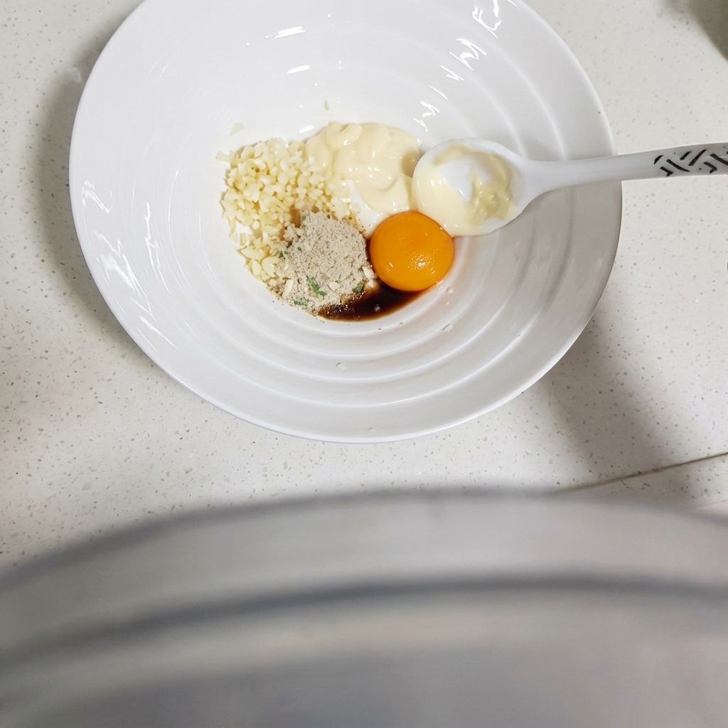 Une cuillère mélangeant les ingrédients dans le bol pour obtenir une pâte lisse et homogène.