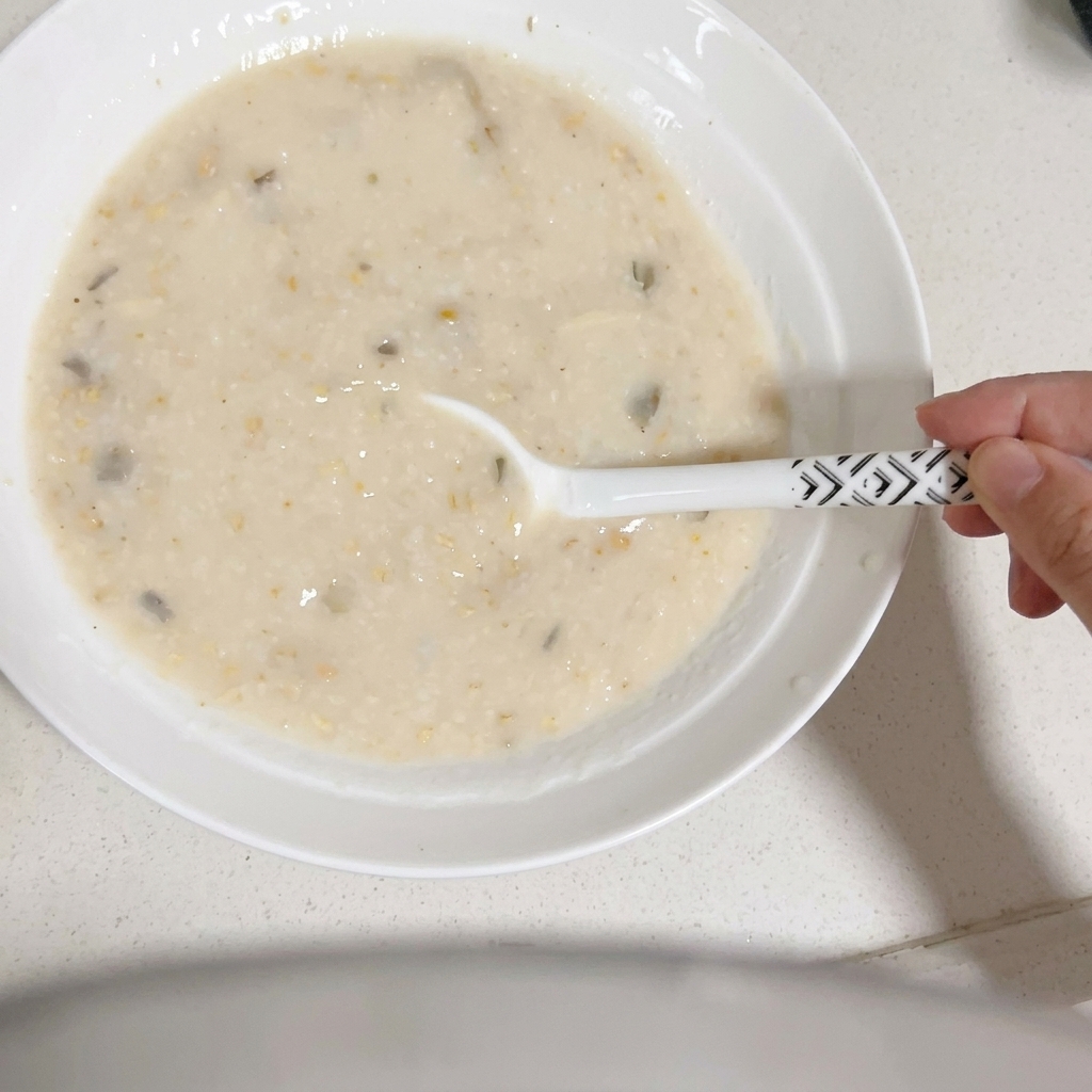 Des nouilles ramen cuites immergées dans le bouillon crémeux avec des baguettes.
