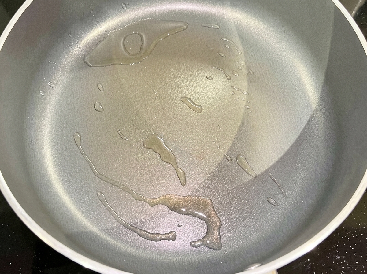 Oignon rouge haché grésillant dans une poêle avec de lhuile de cuisson chaude.
