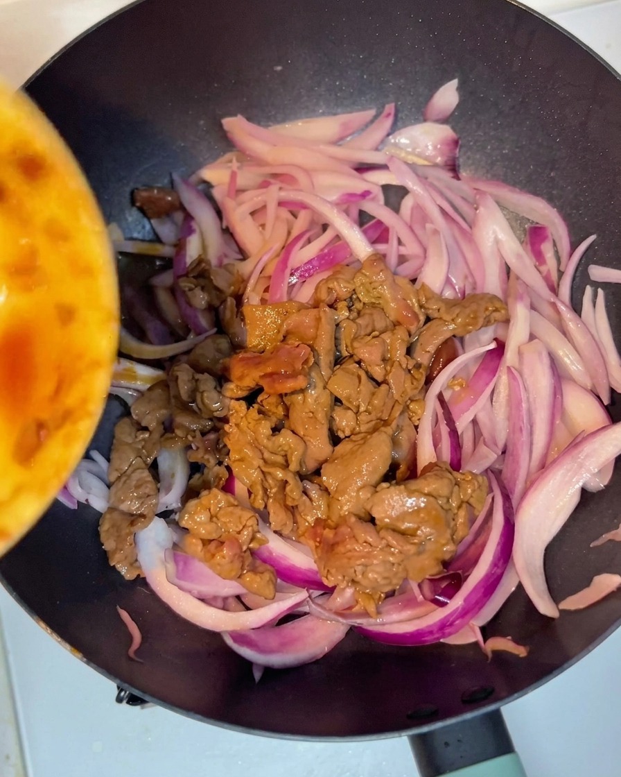 Le bœuf cuit est remis dans la poêle avec les oignons.