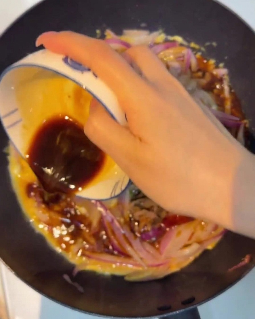 La sauce est versée uniformément sur la poêlée.