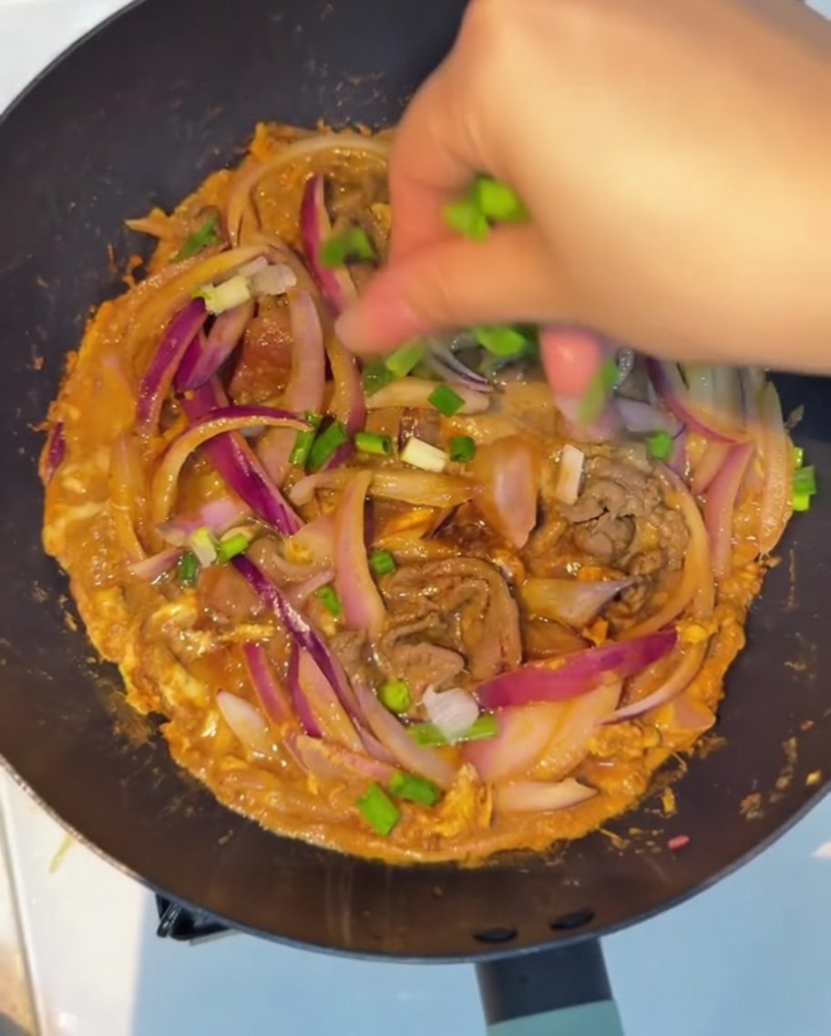 Oignons verts frais saupoudrés sur le plat terminé.