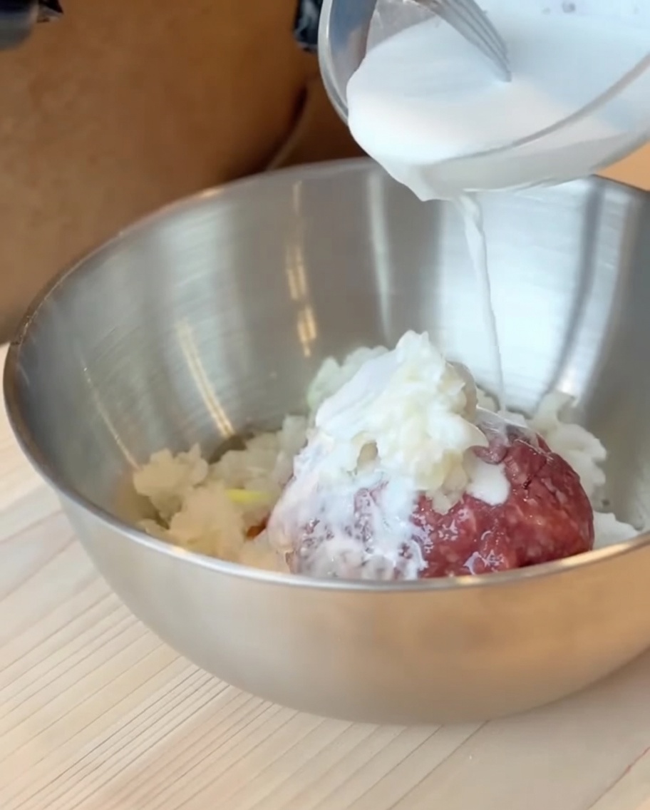 Le mélange lait et farine de patate douce versé sur la préparation à base de bœuf dans un grand bol.