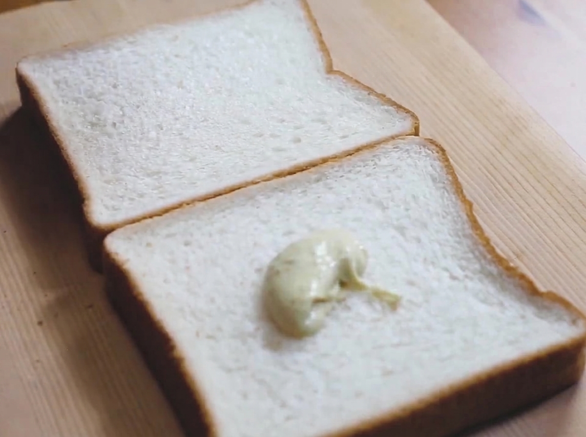 Une noisette de sauce verte claire sur une tranche de pain de mie.