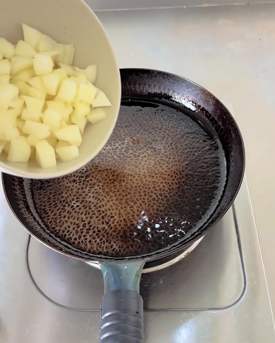 Des oignons blancs hachés versés dun bol dans une poêle avec de lhuile chaude bouillonnante.