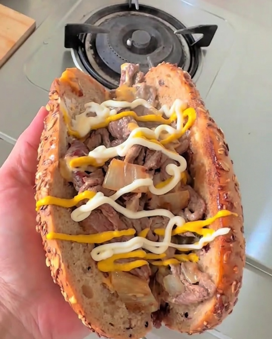 Gros plan dun pain garni nappé de tourbillons de mayonnaise et de moutarde jaune.