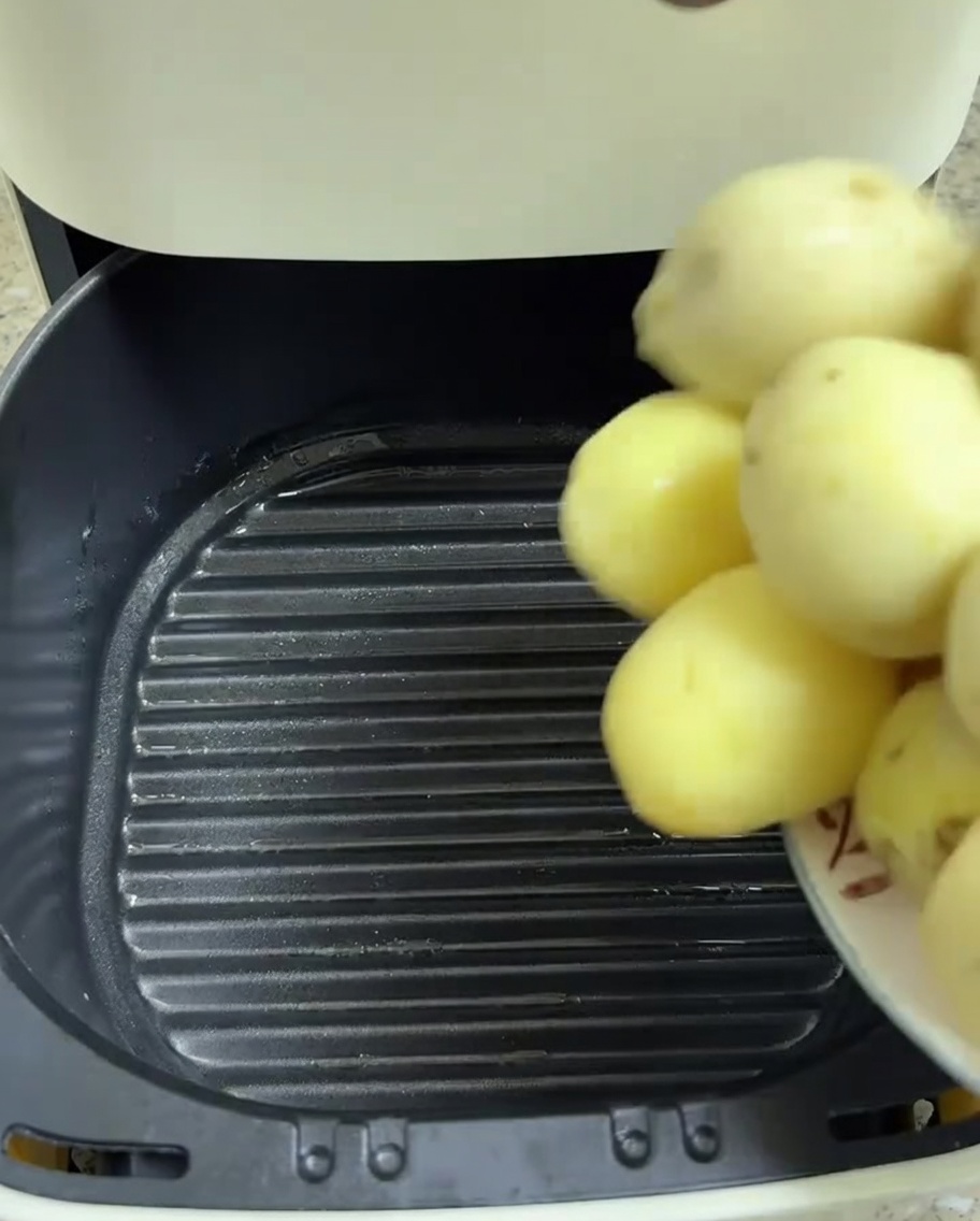 Petites pommes de terre pelées transférées dans le panier de lAir Fryer.
