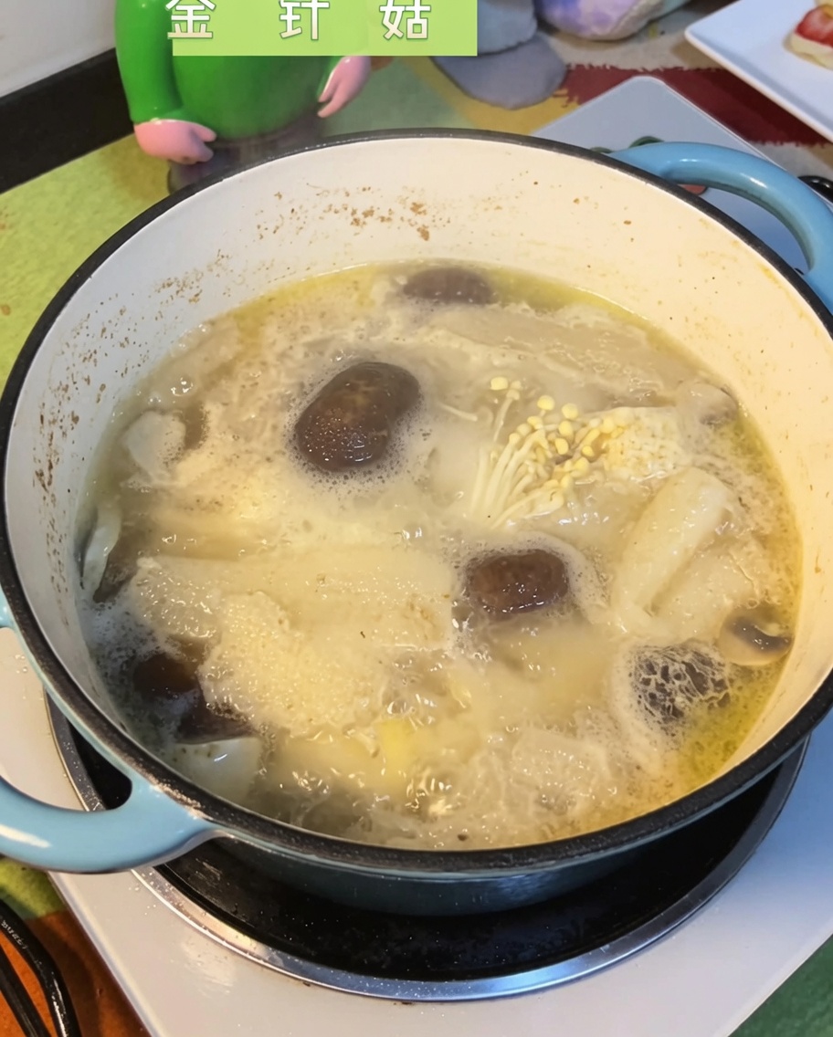 Champignons enoki immergés dans le bouillon bouillonnant.