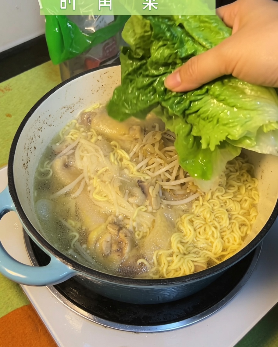 Feuilles de bok choy fraîches ajoutées dans la soupe de nouilles au poulet terminée.
