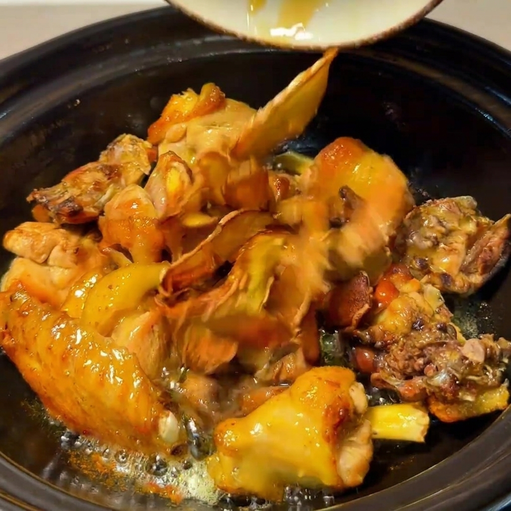 Poulet, champignons, gingembre frit et dattes rouges mijotant ensemble dans le pot en argile.
