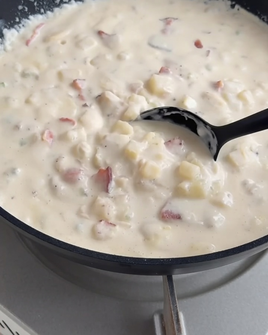 La chowder crémeuse versée à la louche dans le bol de pain croustillant.