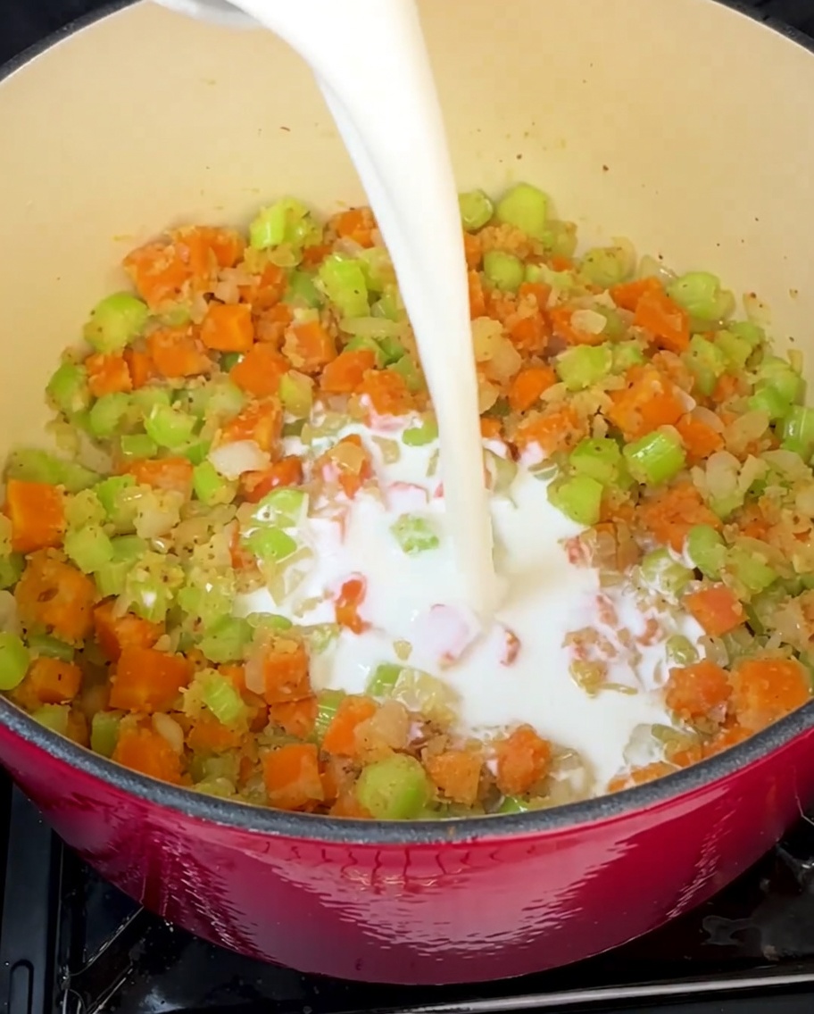 Crème et lait versés dans la marmite pour créer la base de soupe riche et onctueuse.