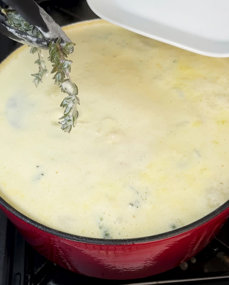 Ciboulette fraîchement hachée étant incorporée dans la chaudrée de palourdes crémeuse.