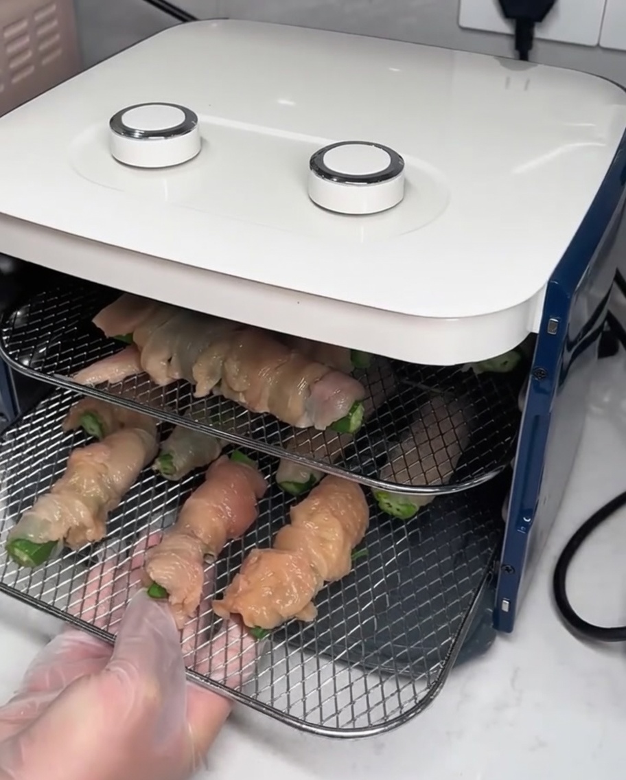 Grilles de séchage avec des wraps de poulet insérées dans un déshydrateur alimentaire.
