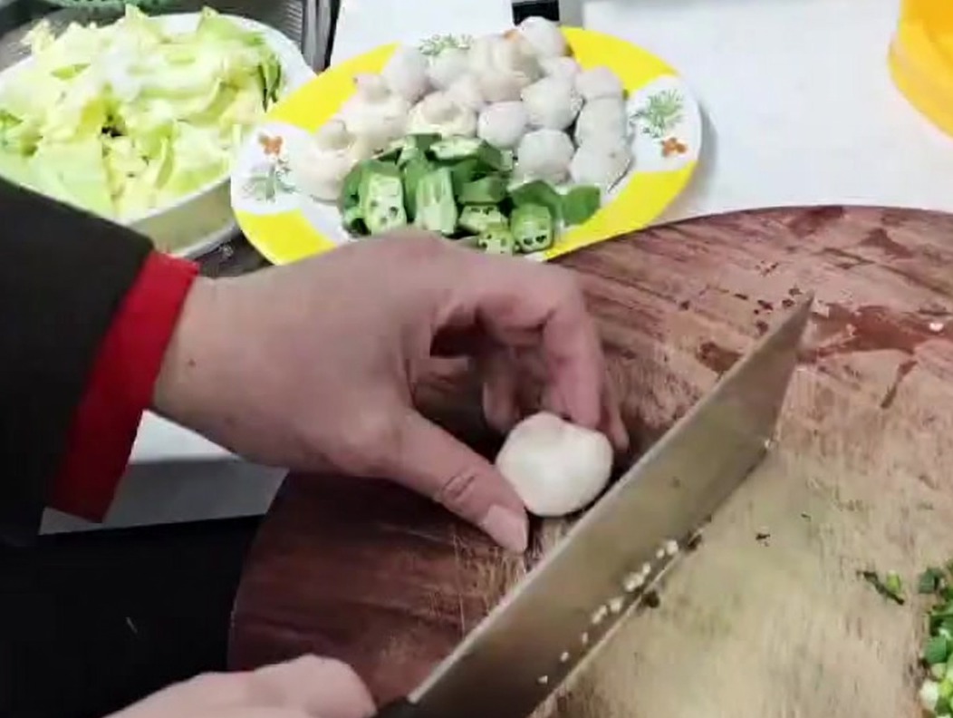 Champignons de Paris coupés en petits morceaux sur une surface en bois.