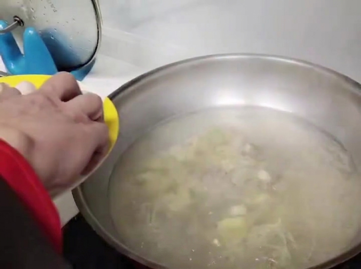 Boulettes rondes soigneusement placées dans leau bouillante dun wok en acier inoxydable.