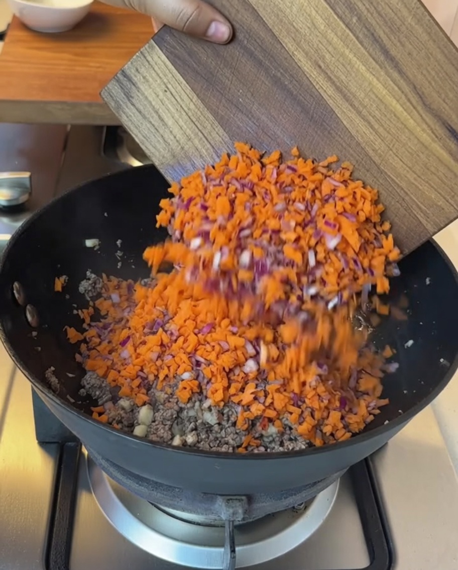 Légumes hachés et tomates en dés ajoutés à la poêle avec le bœuf cuit.