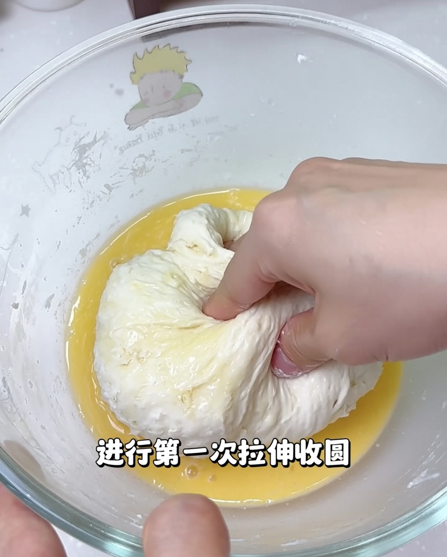 Mains étirant et repliant la pâte à pizza dans un bol pour développer sa texture.