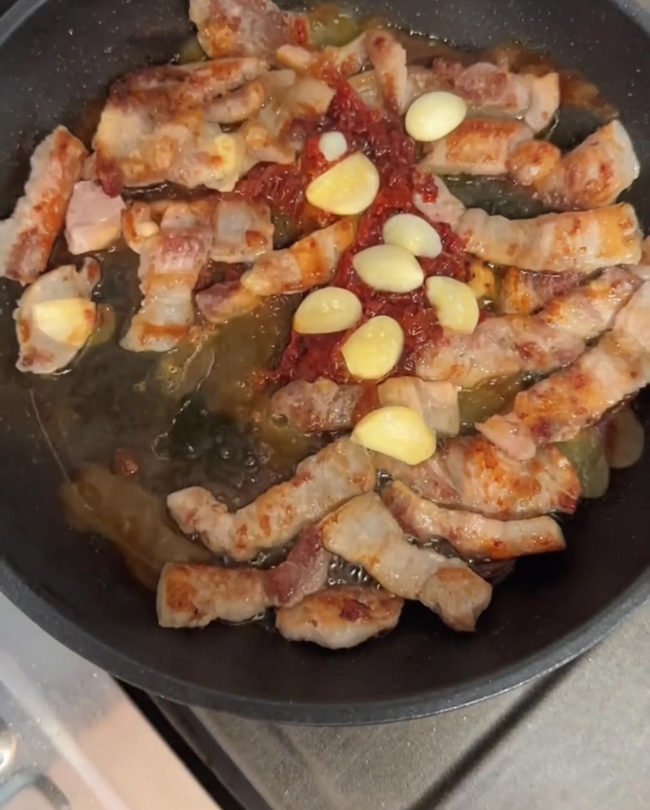 Porc et ail sautés avec la sauce dans la poêle.