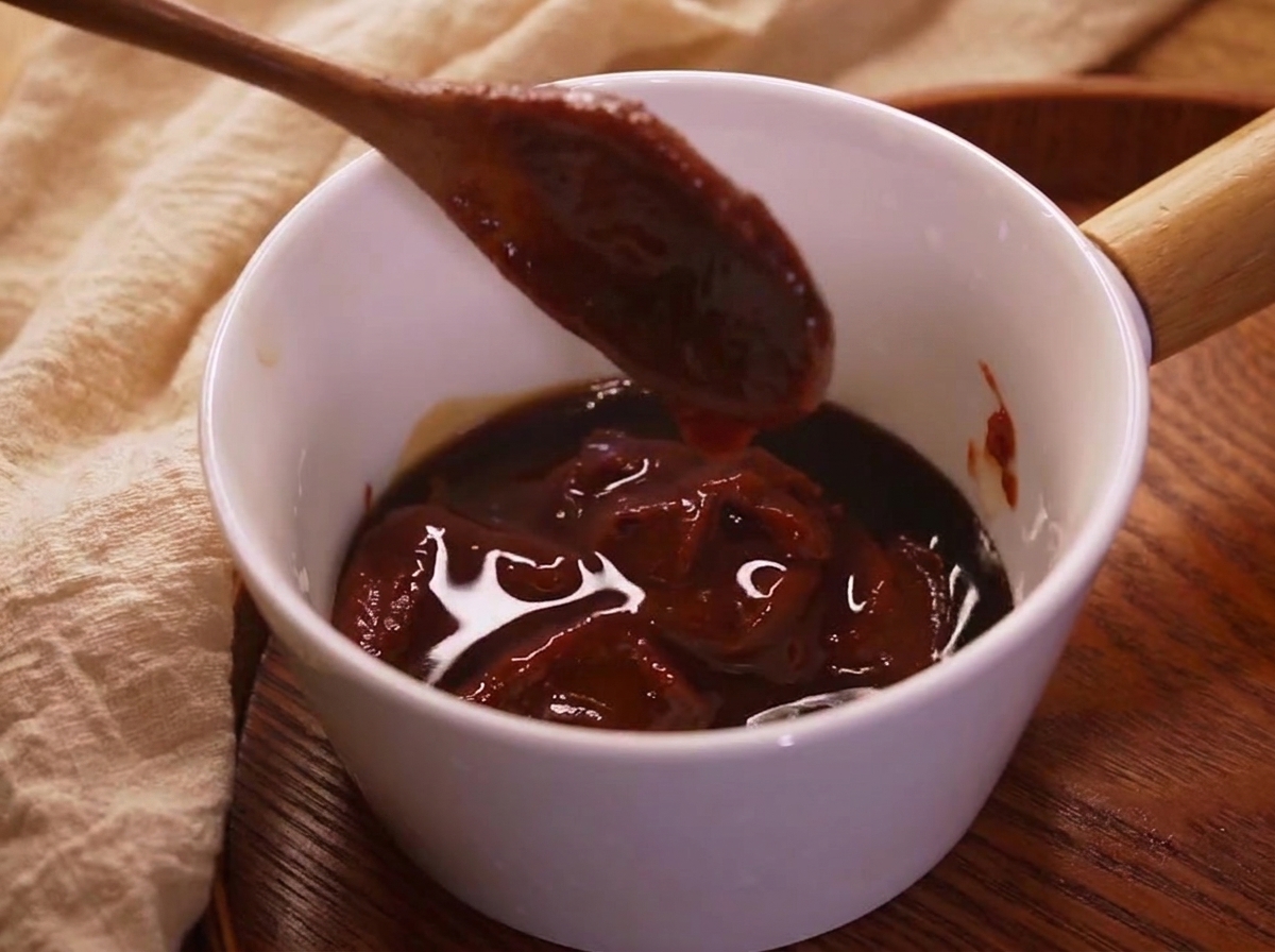La sauce bibimbap préparée dans un petit bol, montrant une couleur rouge riche.
