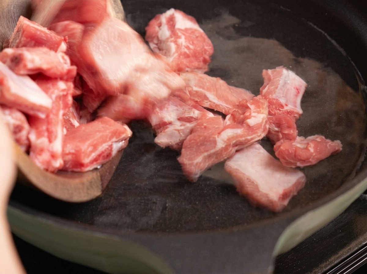 Travers de porc blanchis dans une casserole deau avec du gingembre et des oignons verts.