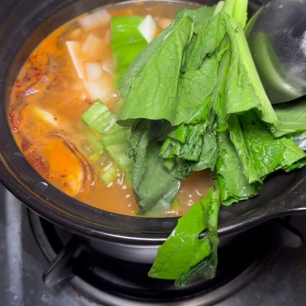 Ajout final de bok choy et doignons dans le ragoût.