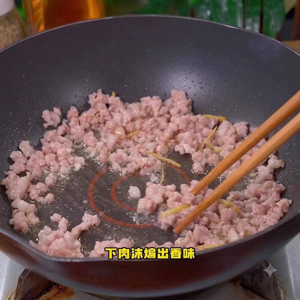 Porc haché en cours de cuisson et remué dans le wok.