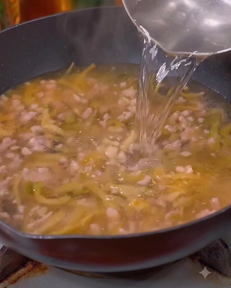 Eau versée dans le wok sur la viande et les légumes.