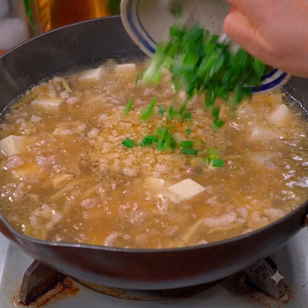 Ciboulette verte hachée et coriandre versées dun bol dans une casserole de soupe bouillante.