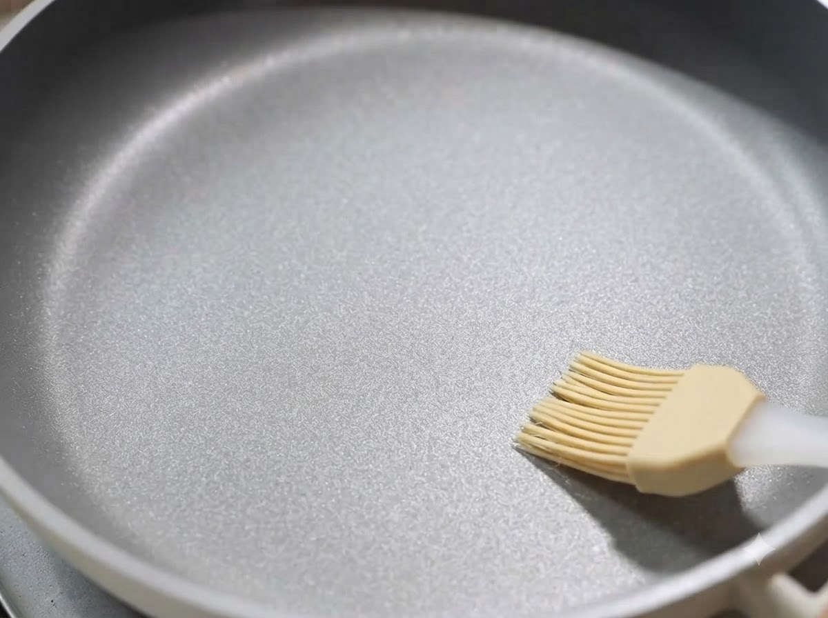 Une poêle antiadhésive badigeonnée dune fine couche dhuile de cuisson.