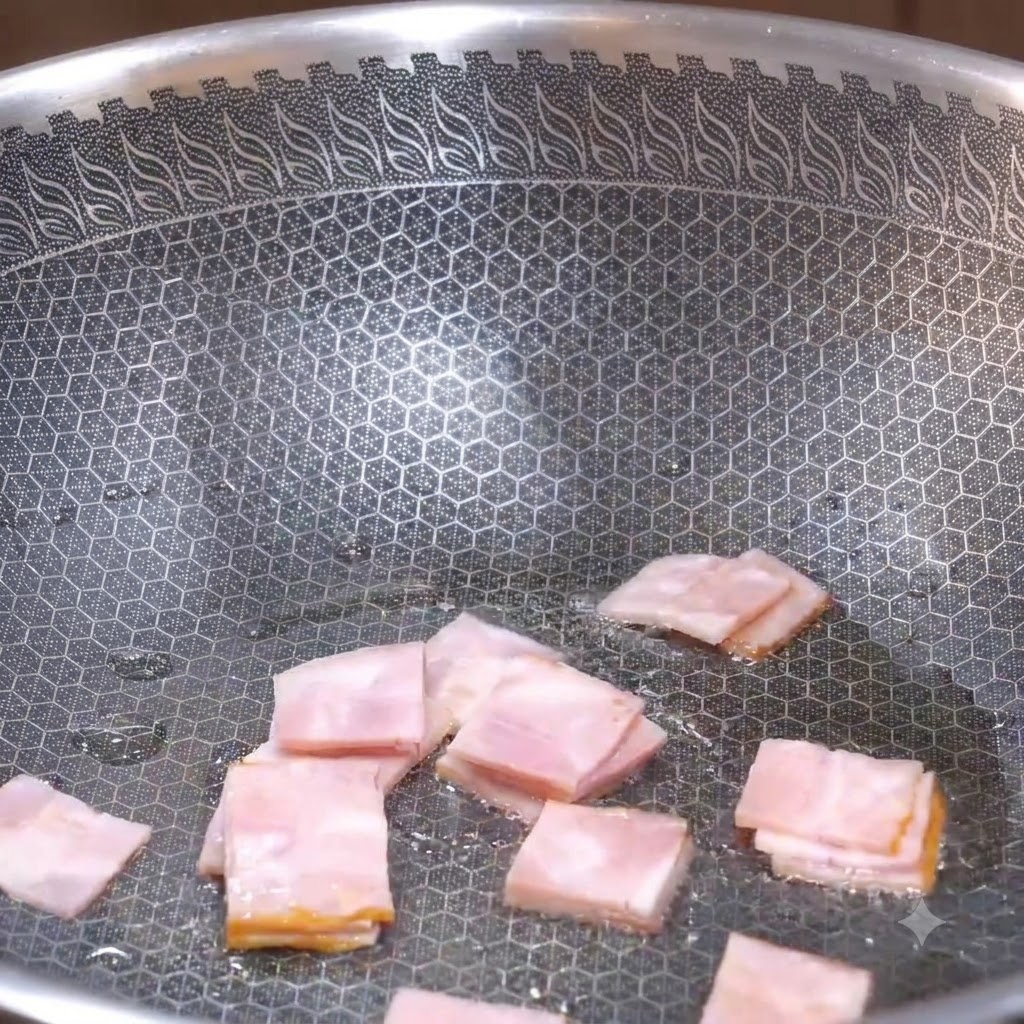 Des morceaux carrés de bacon frits dans un wok texturé jusquà ce quils commencent à brunir.