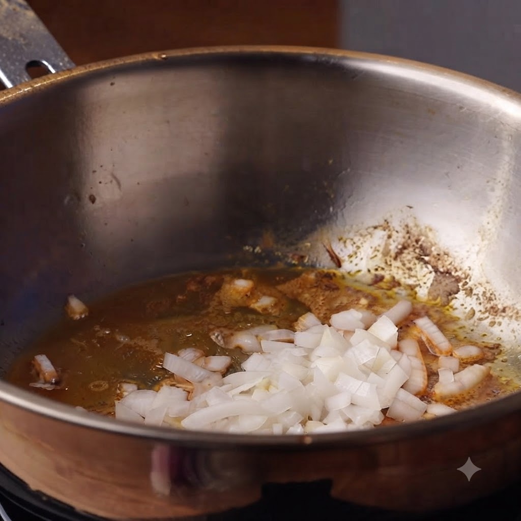 Des oignons hachés et de lail en train de cuire dans lhuile à lintérieur dune casserole profonde.