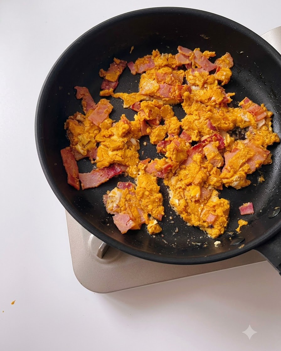 De leau versée dune tasse à mesurer dans une poêle noire contenant lœuf salé et le bacon.