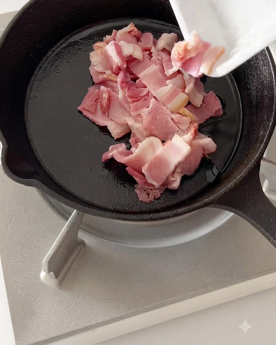 Des morceaux de bacon coupés en train de frire dans une poêle en fonte chaude.