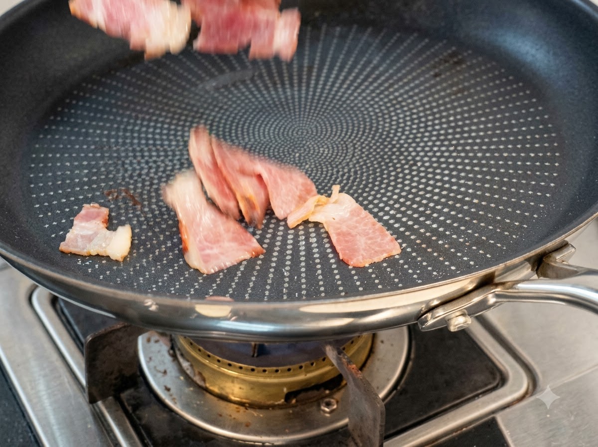 Morceaux de bacon tranchés jetés dans une poêle antiadhésive sèche pour cuire.