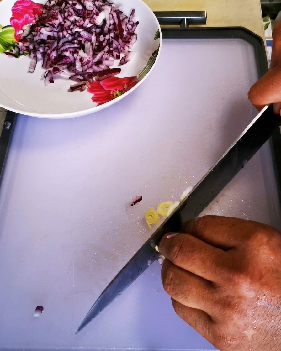 Des gousses dail finement émincées avec un couteau de chef sur une planche à découper.