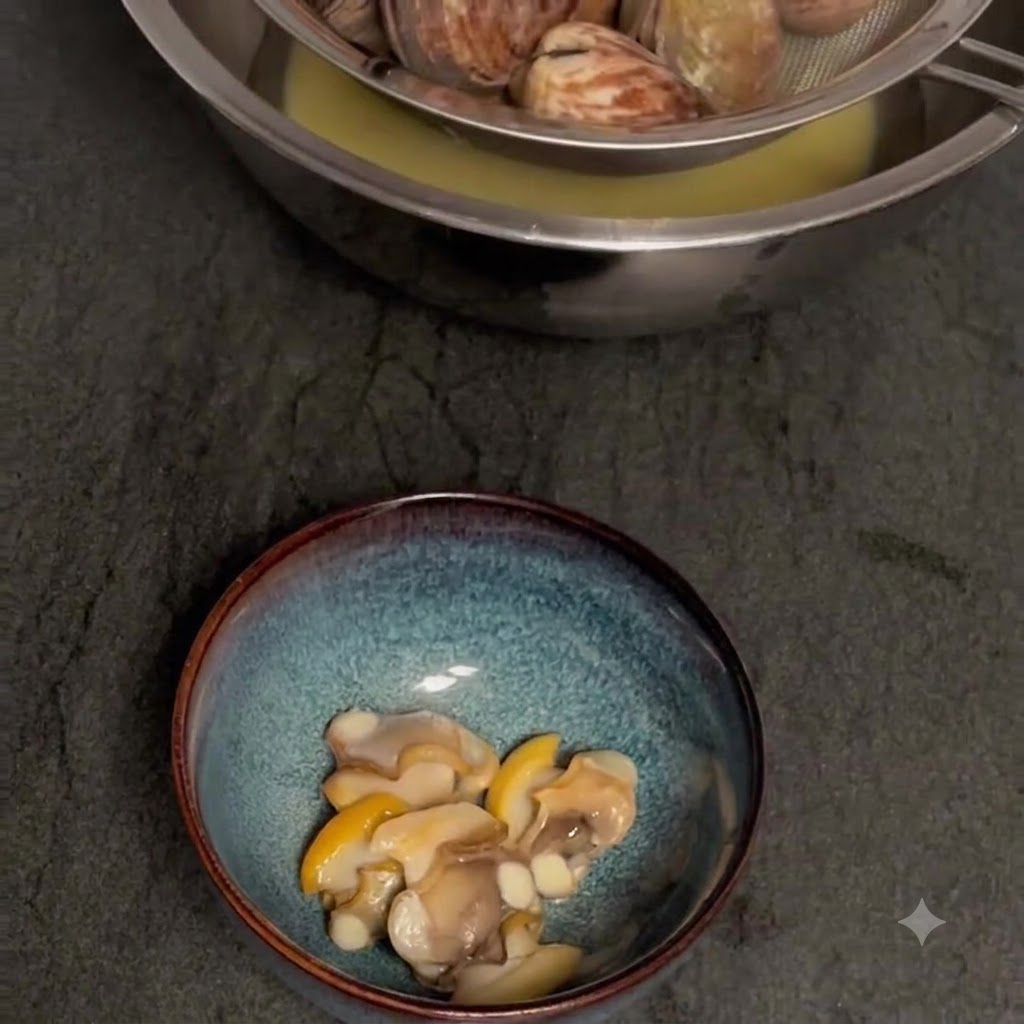 Filtrer les palourdes cuites au-dessus dun bol pour récupérer le bouillon, avec la chair des palourdes décortiquées dans un bol séparé en dessous.