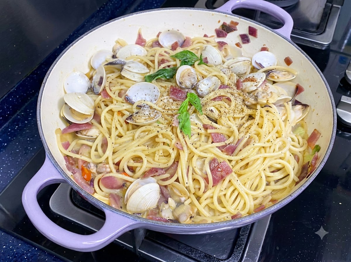 Feuilles de basilic vert frais placées sur le dessus des spaghetti aux palourdes finis.