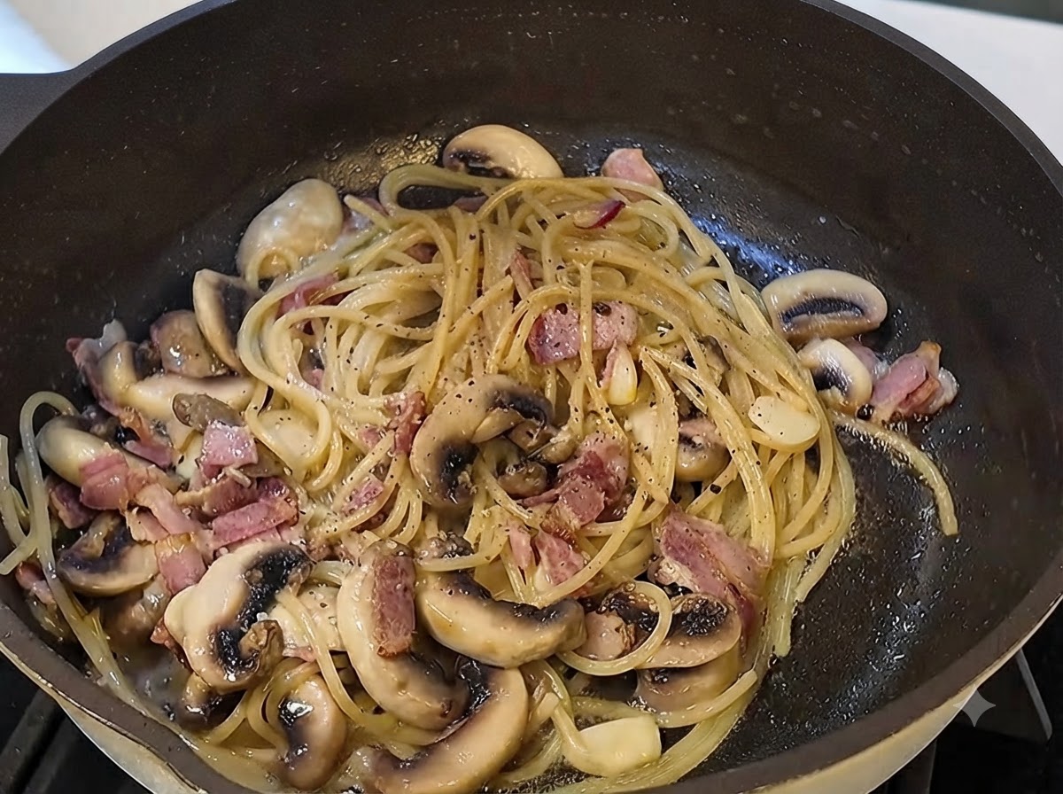 Sauce à la truffe noire et poivre noir fraîchement moulu mélangés aux pâtes dans la poêle.