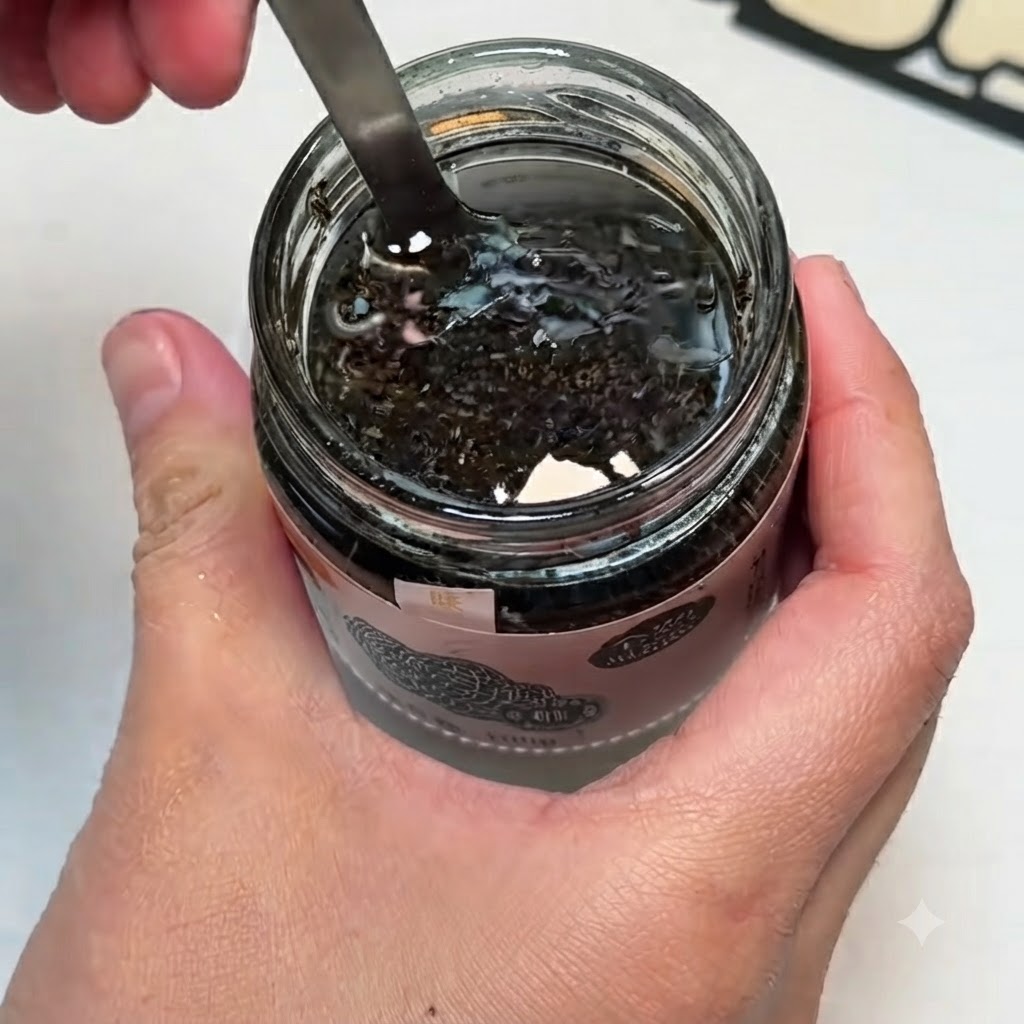 Un petit bol contenant de la sauce à la truffe noire, des jaunes dœufs et du sel mélangés ensemble avec une cuillère.