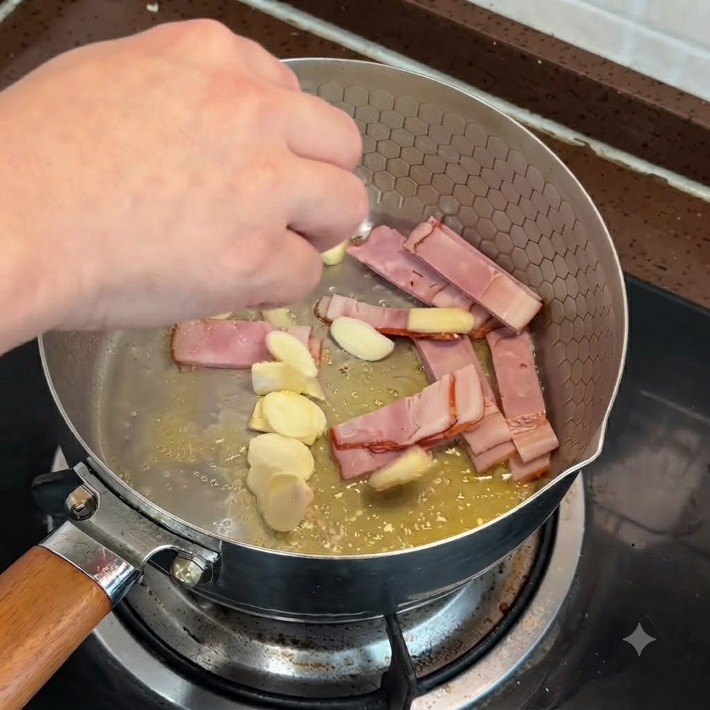 Des morceaux de bacon tranché et dail en train dêtre sautés dans une poêle avec du beurre fondu.