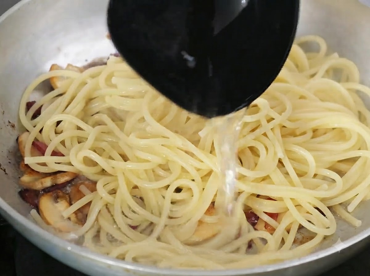 Louche versant de leau de cuisson des pâtes riche en amidon dans la poêle contenant les pâtes et les ingrédients.