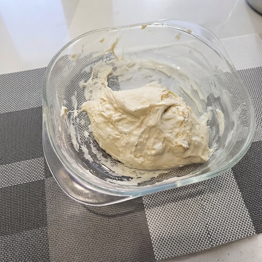 Mélange de pâte à pizza rustique rassemblé dans un bol en verre transparent.