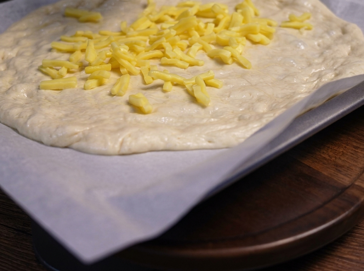 Champignons émincés sautés placés sur la couche de fromage de la pâte à pizza.