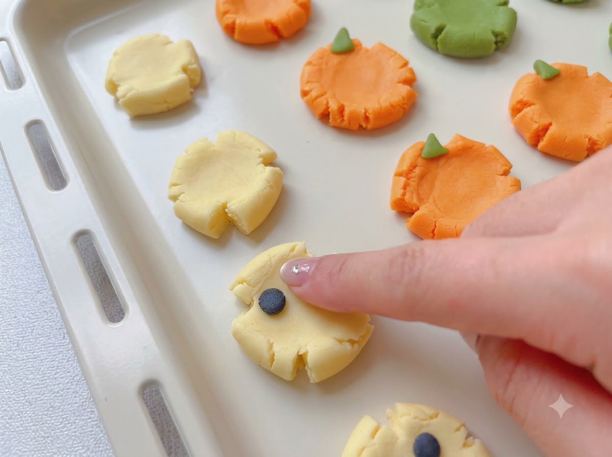 Petits morceaux de pâte colorée fixés sur des bases de biscuits aplaties pour former des motifs effrayants.